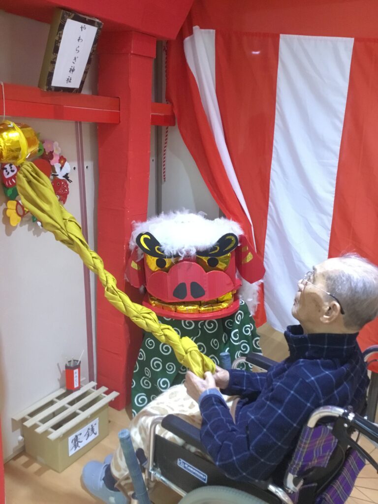 正月飾りと獅子舞を楽しむ入居者。お正月行事の風景。